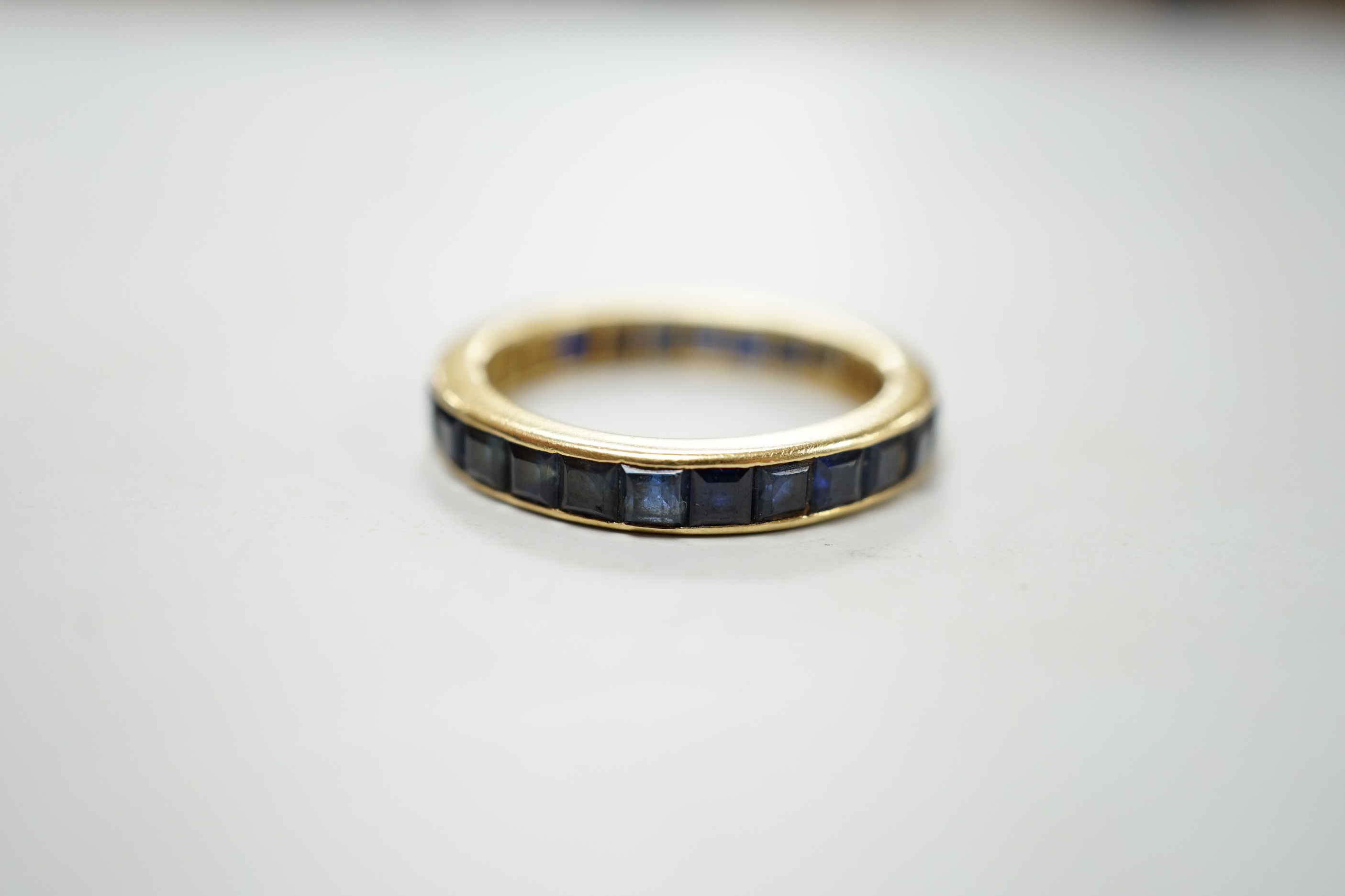 A yellow metal and sapphire set full eternity ring, size R, gross weight 4.6 grams.